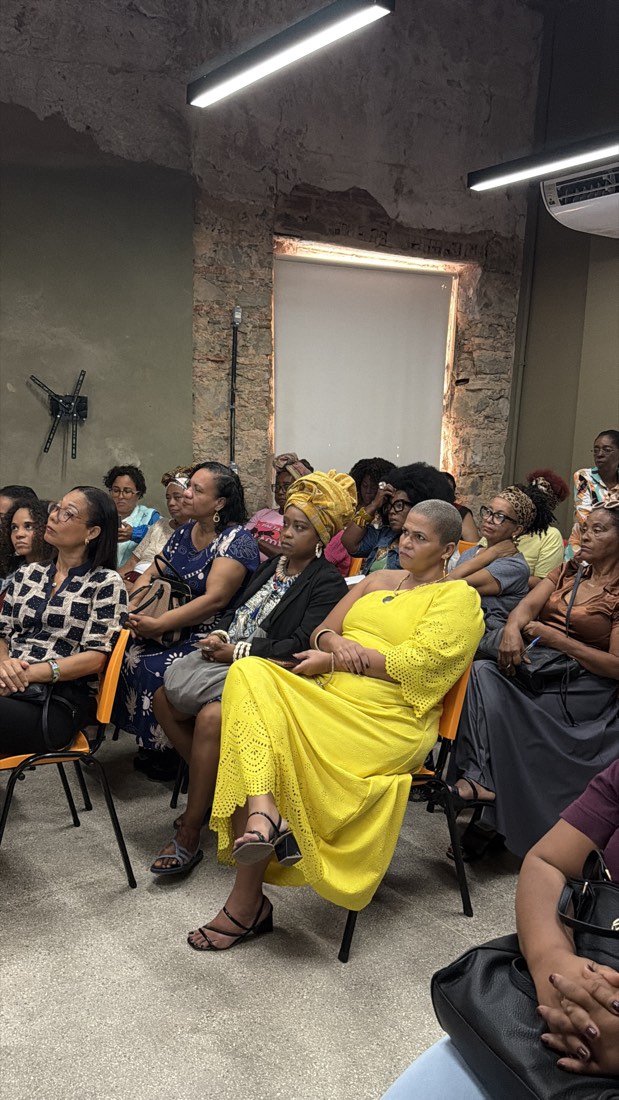 plateia do workshop sentada e atenta, majoritariamente mulheres negras